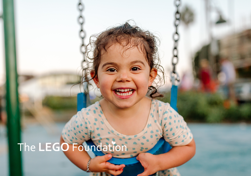 Girl on swing with LEGO logo