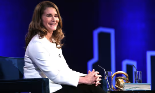 Photo of Melinda French Gates smiling with hands clasped in her lap